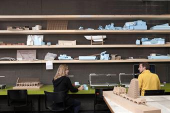 Dieses Bild zeigt zwei Studenten im Laser- und Cutter-Raum des Fachbereichs Architektur der Peter Behrens School of Arts.